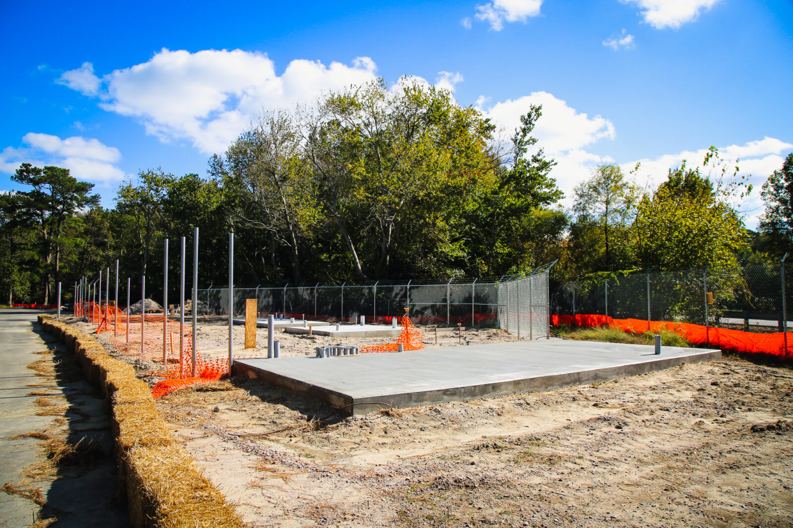 Concrete pad in construction zone with orange fencing around the area