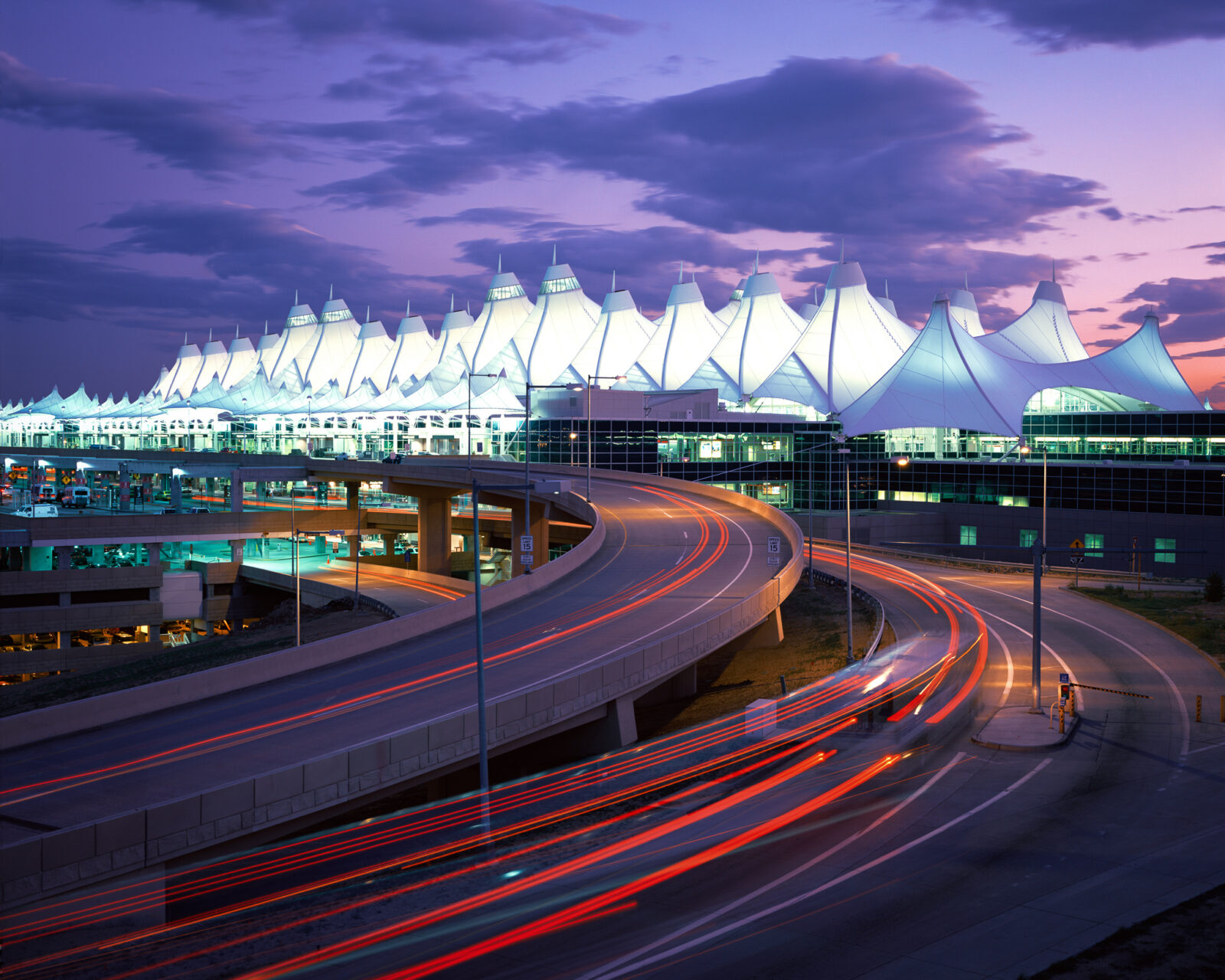 Time capture of cars driving into Denver International Airport at night