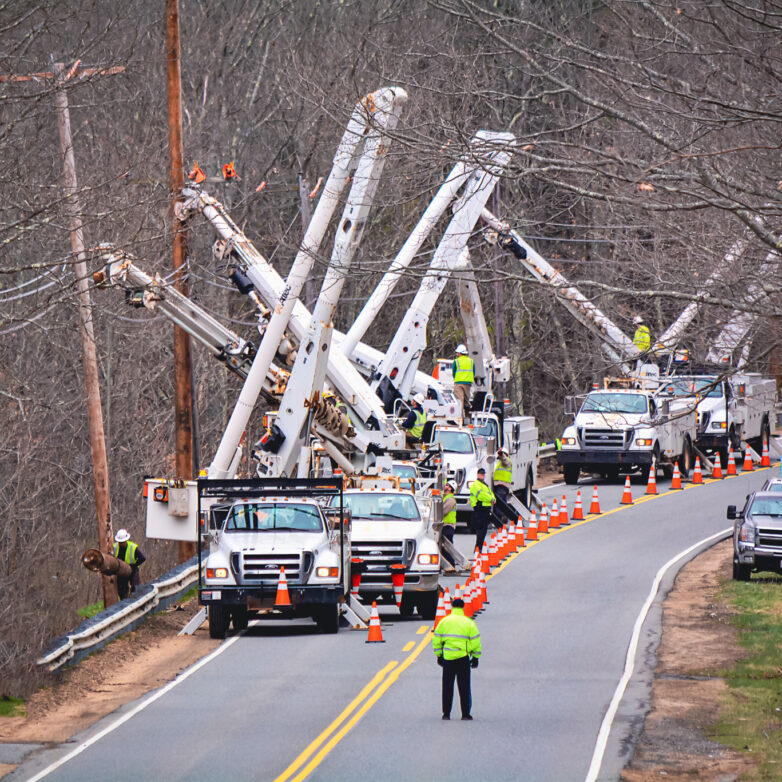 Row of white bucket trucks on a road