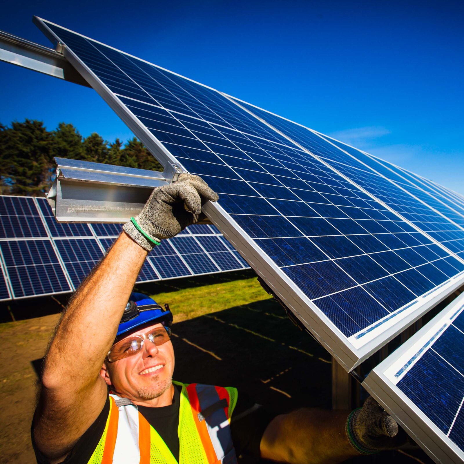 Worker carrying and inserting a solar panel