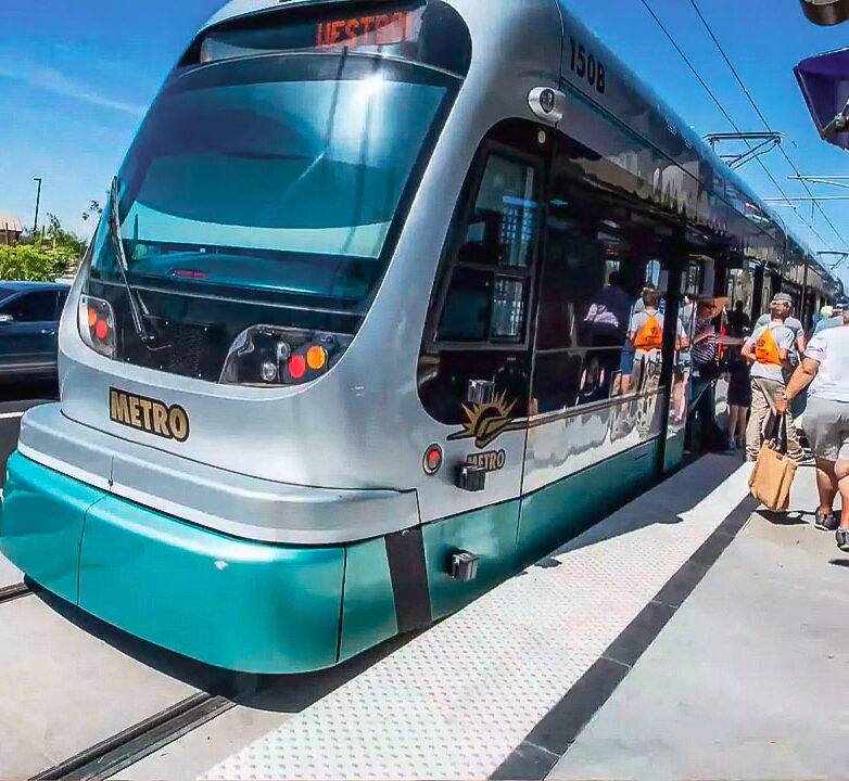 Front of light rail train with people entering and leaving the train