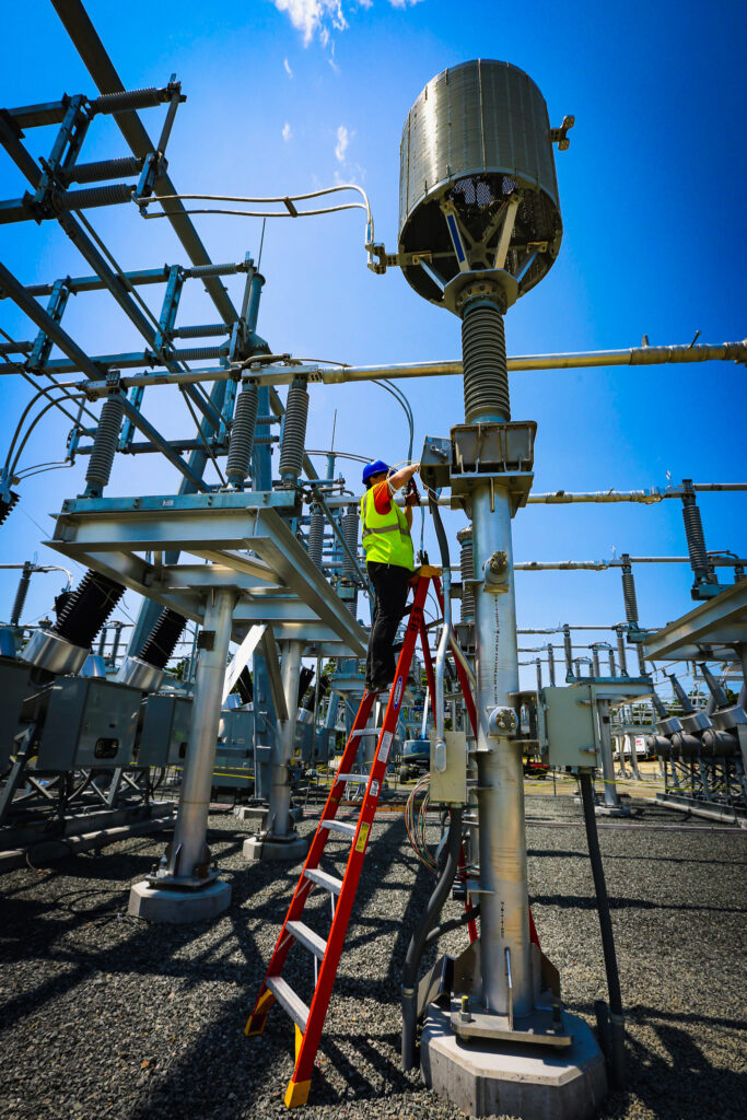 Man on ladder working in a substation